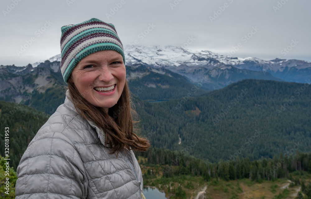Woman Smiles at Camera With Foggy Mt. Rainier