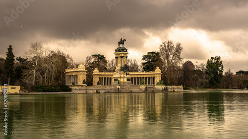 View of the monument of Alfonso XII from the other side of the pond, in the Retiro Park in Madrid. Travel concept.