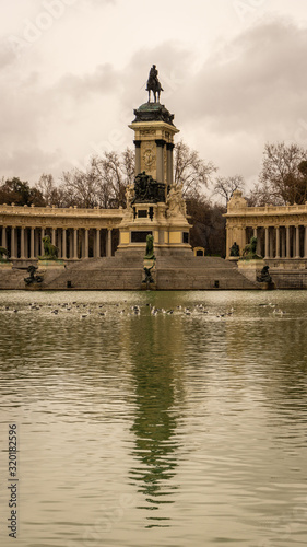 Close-up of the monument of Alfonso XII and its reflection in the Retiro Park on a cloudy winter day in Madrid. Travel concept.
