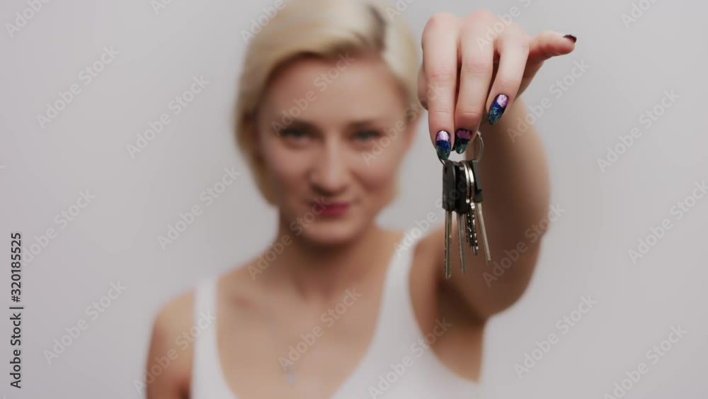 Happy Young Attractive Woman Raising Keys in Hand and Exclaiming Yes with Fists Happy Young Attractive Woman Raising Keys in Hand and Exclaiming Yes with Fists