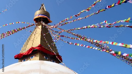 Boudhanath stupa in Kathmandu with buddha eyes and prayer flags on clear Blue sky background. photo