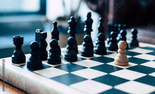 Representation of a business leader facing impossible odds. Single pawn stands against an entire chess board.