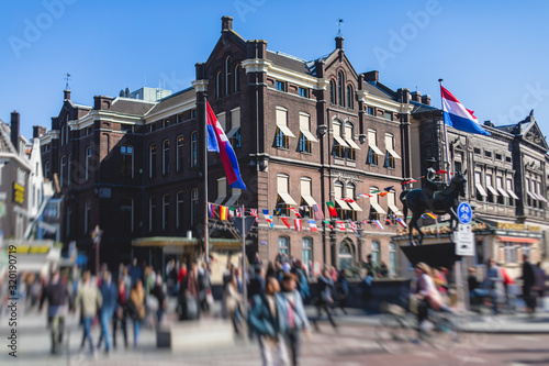 View of Amsterdam street in the historical center, with canal houses in the capital city of Amsterdam, North Holland, Netherlands, summer sunny day photo