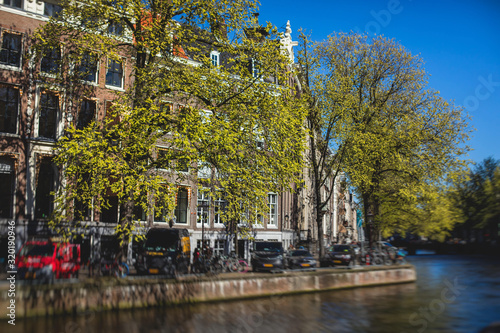 View of Amsterdam street in the historical center, with canal houses in the capital city of Amsterdam, North Holland, Netherlands, summer sunny day © tsuguliev