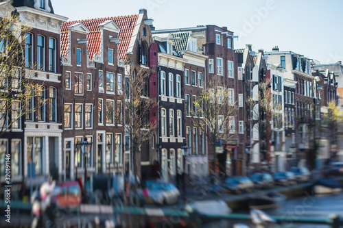 View of Amsterdam street in the historical center, with canal houses in the capital city of Amsterdam, North Holland, Netherlands, summer sunny day photo