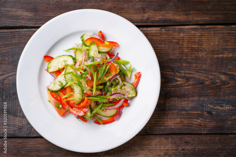 Fresh vegetable salad on a wooden background, concept of healthy and vegetarian food Fresh vegetable salad on a wooden background, concept of healthy and vegetarian food