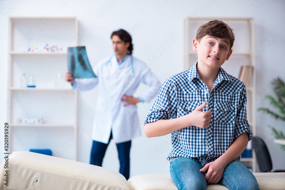 Male radiologist looking at boy's images Male radiologist looking at boy's images