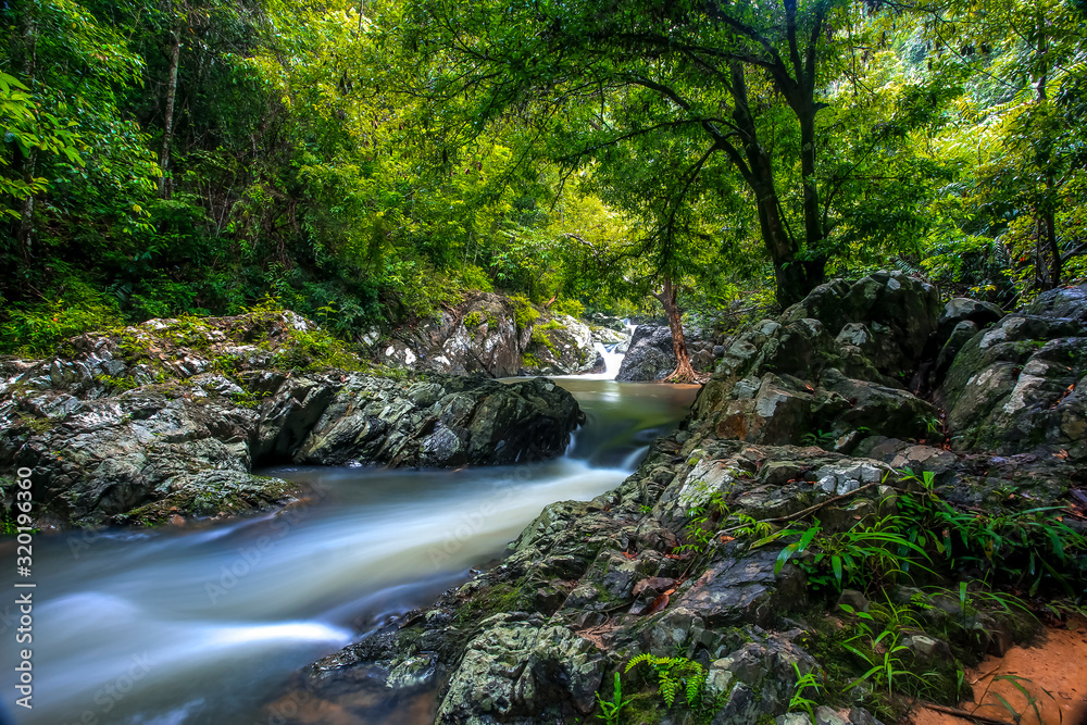 beautiful waterfall and emerald pool of fresh water lake in wild jungle forest environment in Thailand. Travel and adventure landscape of amazing Asia