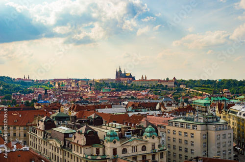 Prague rooftops cityscape skyline as seen from Prague's Old Town Hall Tower. St. Vitus cathedral is visible in the far background.