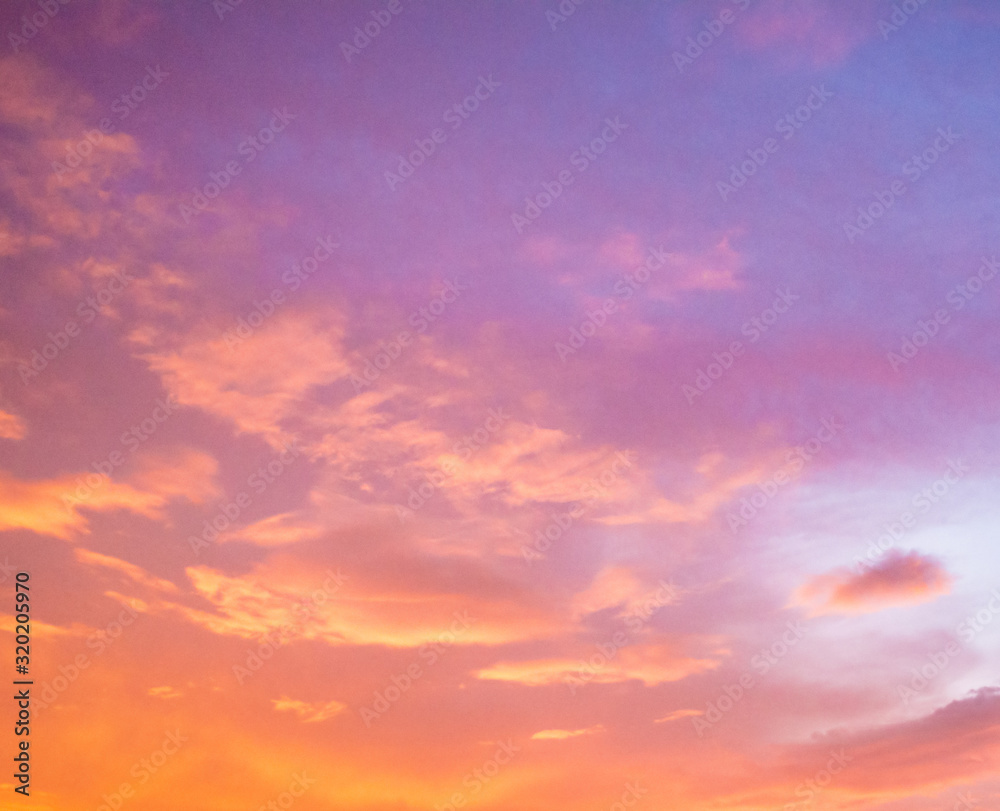 Beautiful cloudy sunset sky with orange, purple, pink, and magenta hue; with vibrant colors. Abstract nature background.