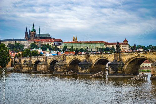 Cityline of Prague at afternoon. Vltava River and Charles Bridge in the foreground, St Vitus Cathedral in the background