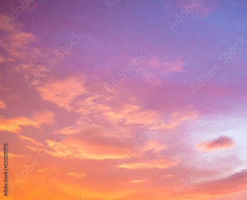 Beautiful cloudy sunset sky with orange, purple, pink, and magenta hue; with vibrant colors. Abstract nature background.