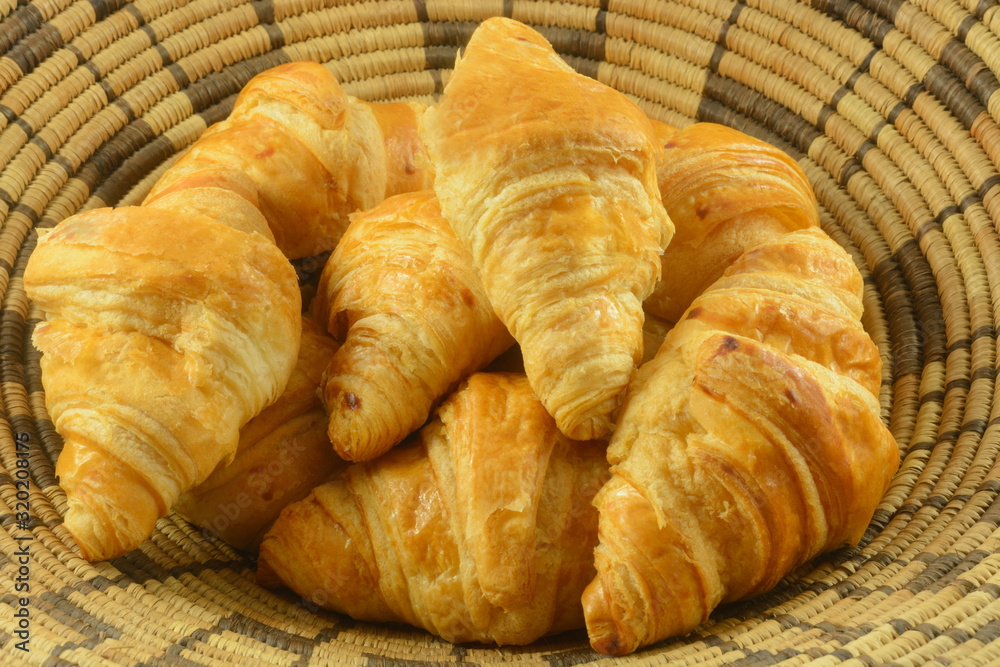Close up of bunch of breakfast croissant pastries in woven basket Close up of bunch of breakfast croissant pastries in woven basket
