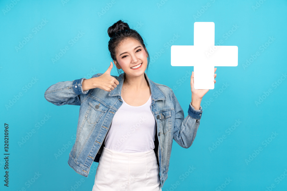 Happiness asian woman smiling, showing plus or add sign and thumb up or like on blue background. Cute asia girl wearing casual jeans shirt and showing join sign for increse and more benefit concept Happiness asian woman smiling, showing plus or add sign and thumb up or like on blue background. Cute asia girl wearing casual jeans shirt and showing join sign for increse and more benefit concept