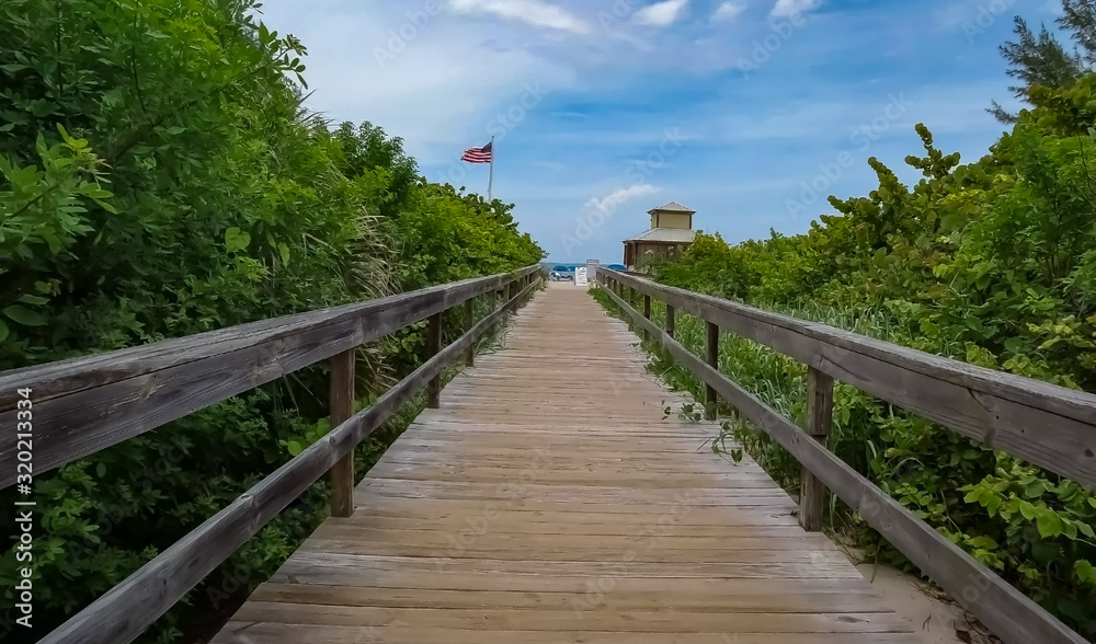Boardwalk pathway to the beach to the ocean sands with a view of the beautiful sky 