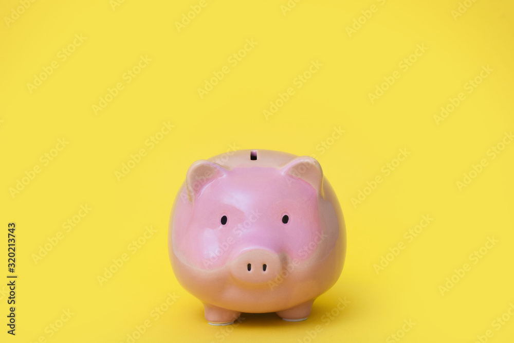 A pink piggy bank. Yellow background.