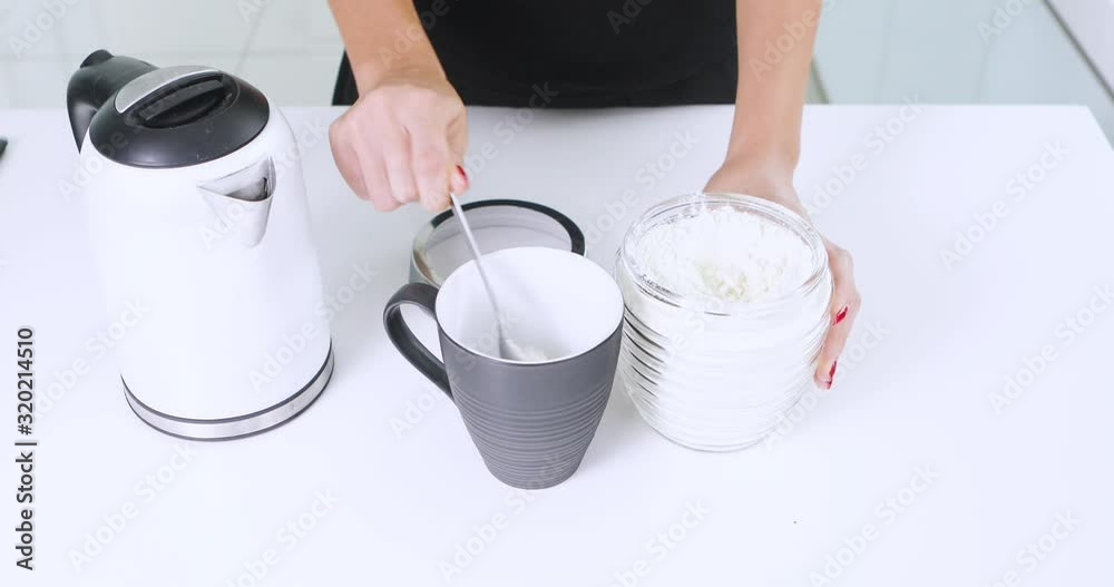 Hands of young woman making a cup of hot milk Hands of young woman making a cup of hot milk