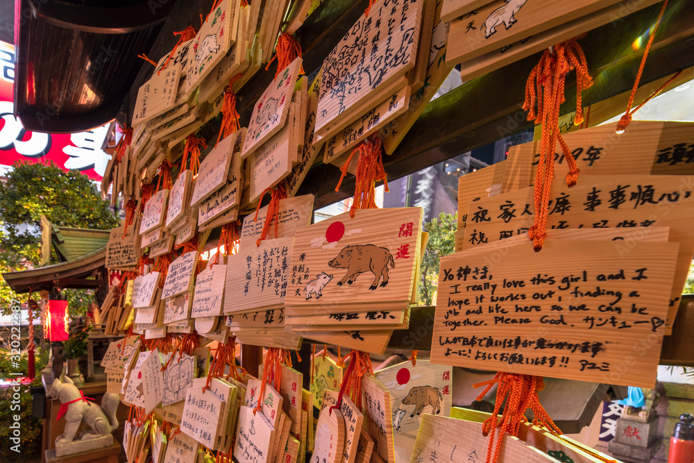 Shinto wooden plaques decorated with a boar and of worshippers prayers in the Tokudaiji temple of Tokyo.
