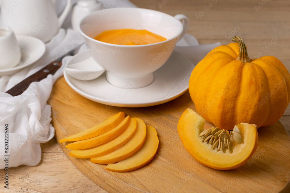 Pumpkin sliced on wooden board with soup on the wooden table. Pumpkin sliced on wooden board with soup on the wooden table.