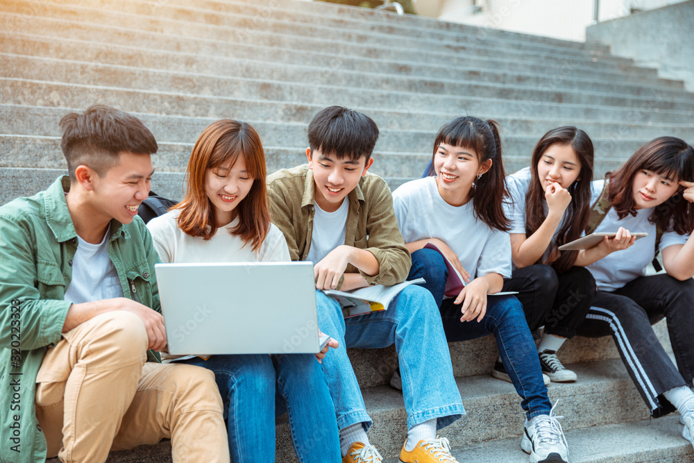 Group of students studying on the stairs at campus Group of students studying on the stairs at campus