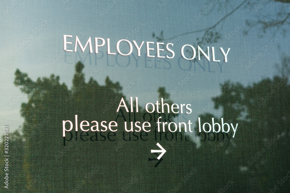 Employees only sign on the glass door leading to office directs company ...