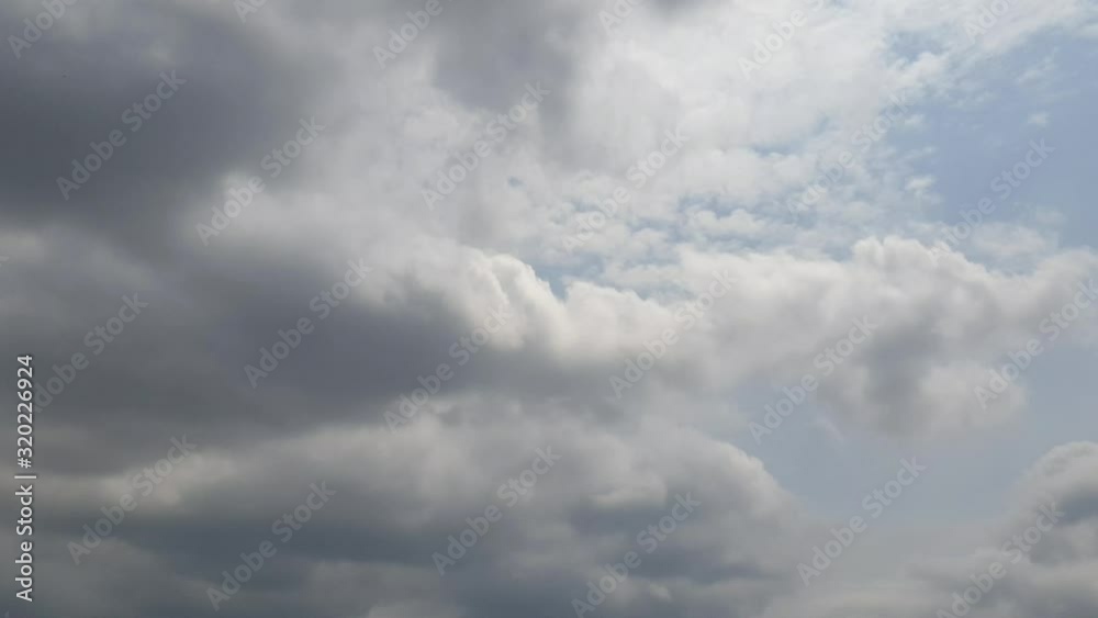 Blue summer sky with dense thick thunderstorm rain clouds moving across the heavens. Fast cloud formation and movement creating a surreal time lapse. Blue summer sky with dense thick thunderstorm rain clouds moving across the heavens. Fast cloud formation and movement creating a surreal time lapse.