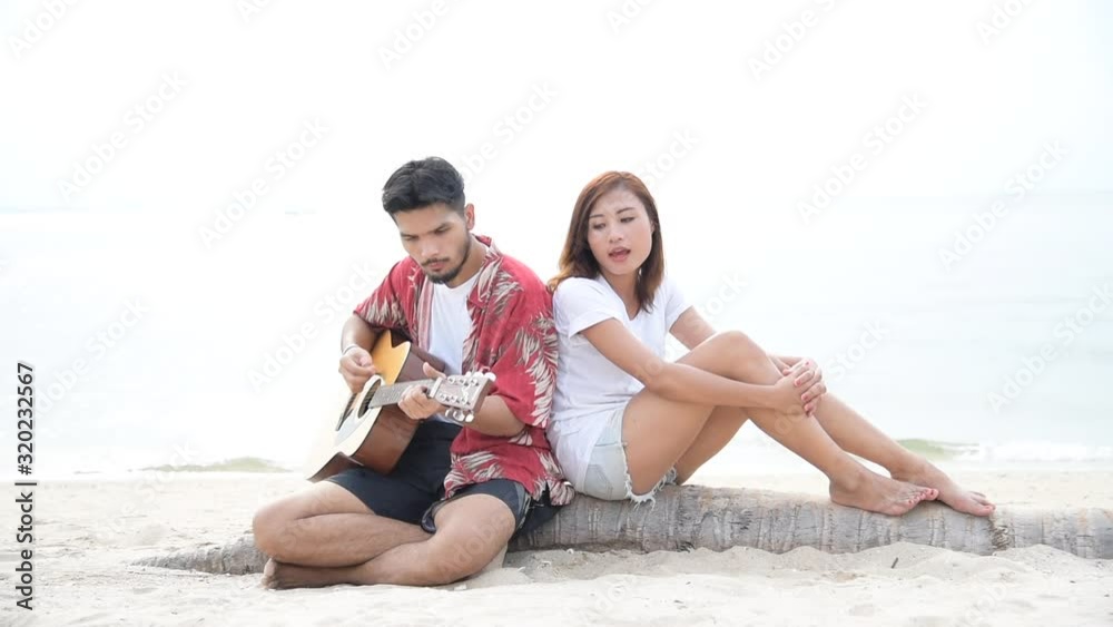 Couple lover paying guitar and singing together have date on valentines' day. Young latin dating together romantic moment with happiness romance. girlfriend boyfriend on beach Valentine's day concept Couple lover paying guitar and singing together have date on valentines' day. Young latin dating together romantic moment with happiness romance. girlfriend boyfriend on beach Valentine's day concept