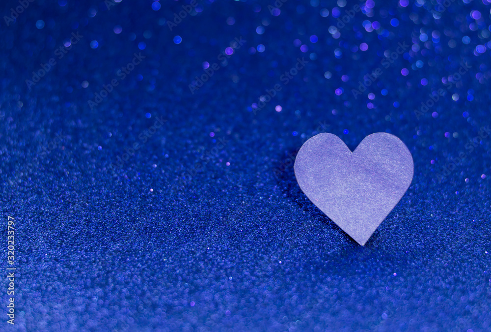 Blue heart on a blue shiny background. Monochrome photography.