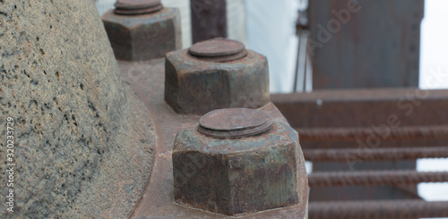 Large rusty nuts on a latch. Stop valves of large sizes.
