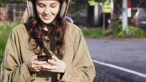 Girl traveler text a message on the phone stopping on a bike at the edge of the road