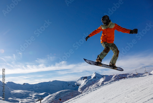 Snowboarder jumps in snow park in the snowy mountains