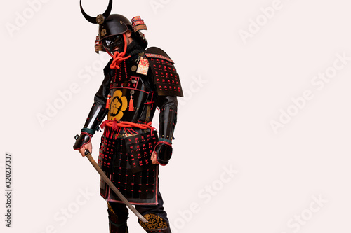 Obraz na plátně warrior with a black samurai armor posing with a white background