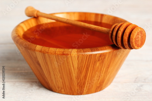 Honey with Honey Dipper in Wooden Bowl photo