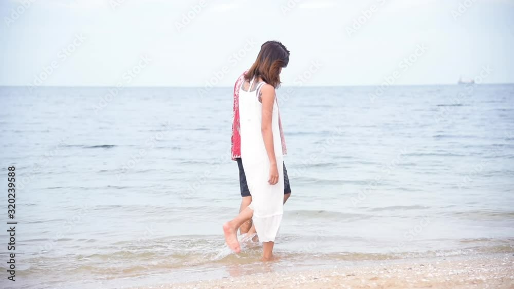 Honeymoon couple lover walking on the beach romantic relationship happiness moment with love lifestyle. Couple lover walk a long beach holding hands together as a date on valentine 's day. Honeymoon couple lover walking on the beach romantic relationship happiness moment with love lifestyle. Couple lover walk a long beach holding hands together as a date on valentine 's day.