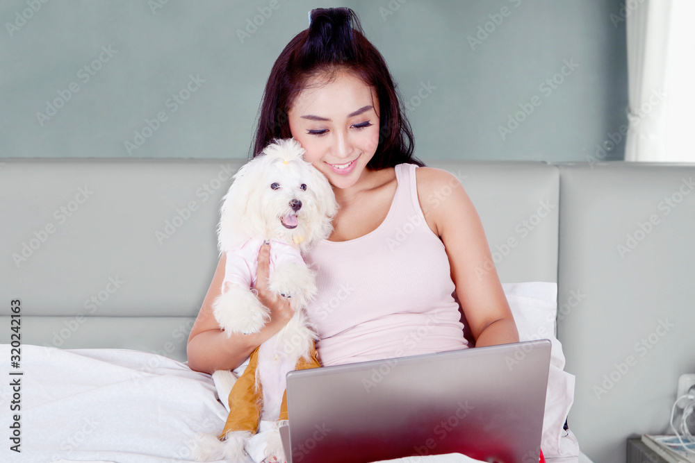 Portrait of woman working with her Bolognese dog Portrait of woman working with her Bolognese dog