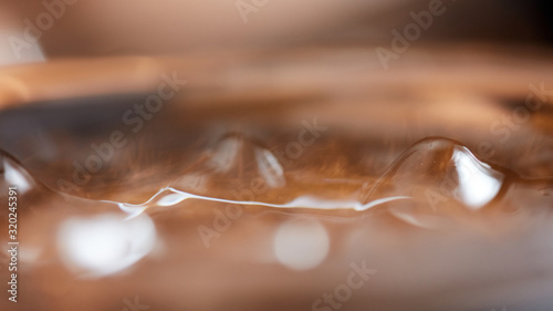 Abstract rippled background texture. Surface of water frozen in time, hi contrast lighting exposes the fascinating patterns created by soundwaves traveling directly through it. 
