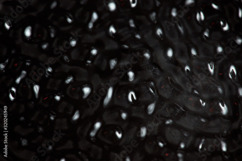 Abstract rippled background texture. Surface of water frozen in time, hi contrast lighting exposes the fascinating patterns created by soundwaves traveling directly through it. 