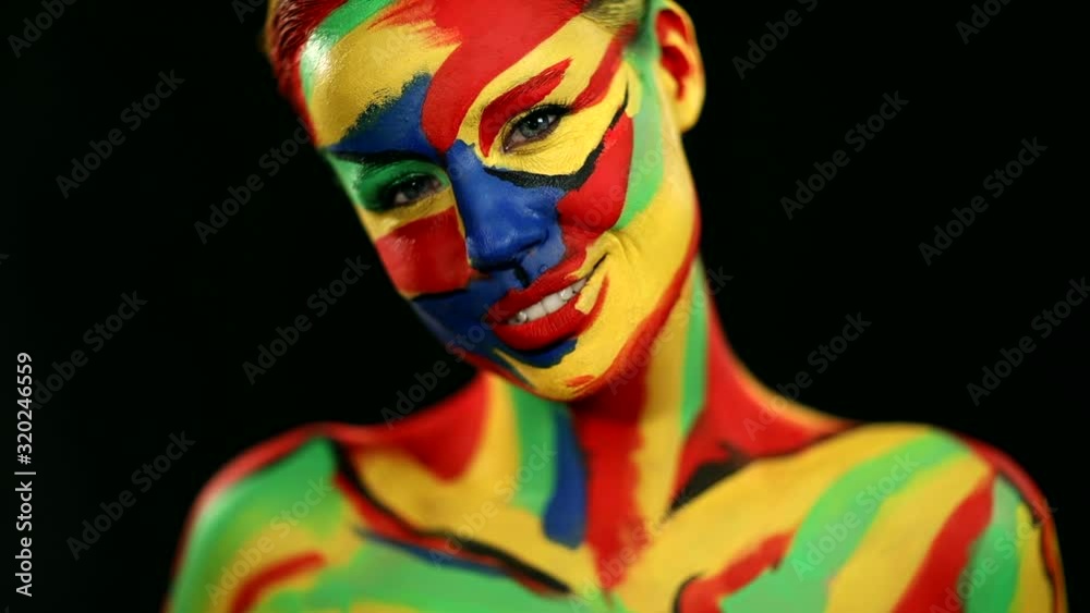 Woman with color face art and body paint. Colorful portrait of the girl with bright make-up and bodyart. Slowmotion. Woman with color face art and body paint. Colorful portrait of the girl with bright make-up and bodyart. Slowmotion.