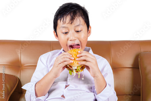 Portrait of boy eating a tasty hamburger
