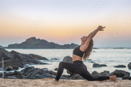 Girl doing yoga on the beach © Filip