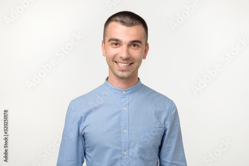 Happy smiling hispanic guy looking at camera isolated on white background