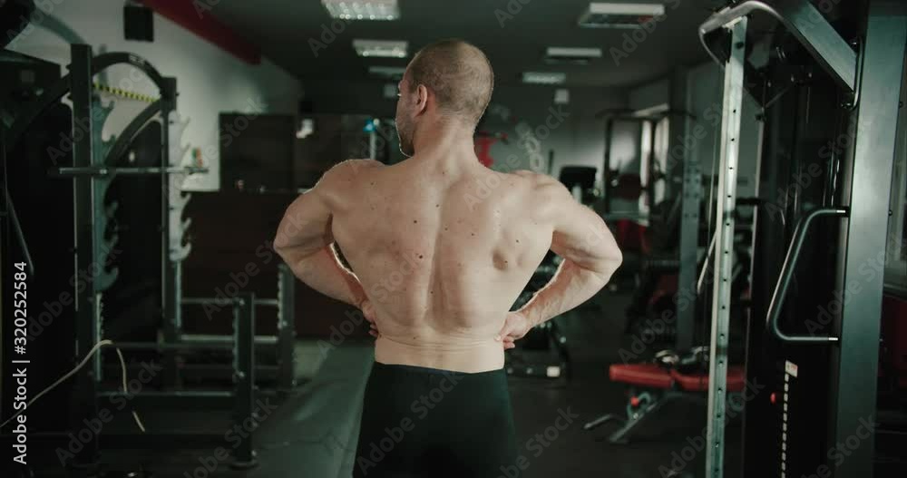 Muscular man is showing off his strong back latissimus dorsi after ...