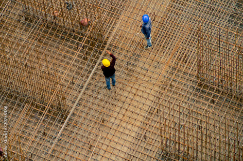 Construction workers in India standing on a rebar reinforcing bar platform making a pillar photo