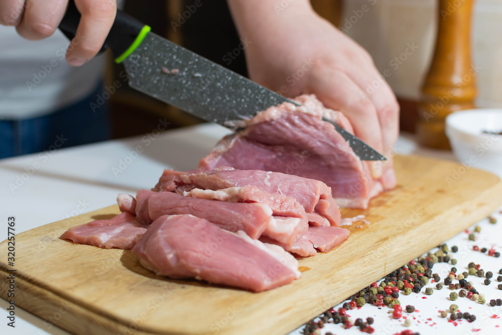 Slicing fresh meat on a kitchen board