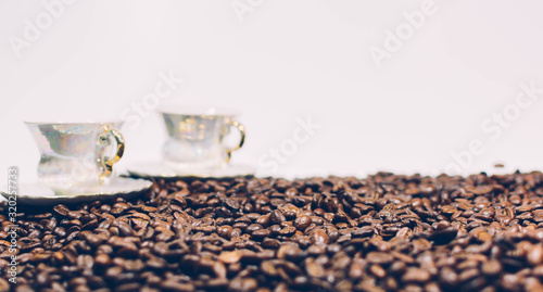 Retro style coffee beans on a white background and two cups.
