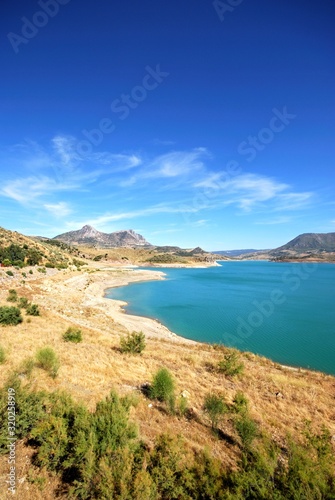View across the reservoir towards the mountains (Embalse de Zahara), Zahara de la Sierra, Spain. © arenaphotouk