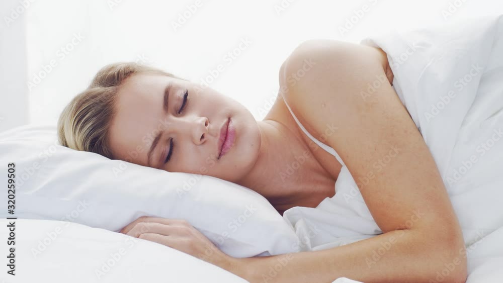 Young woman lying in the bed. Beautiful blond sleeping girl. Morning in the bedroom. Health and rest concept. Young woman lying in the bed. Beautiful blond sleeping girl. Morning in the bedroom. Health and rest concept.