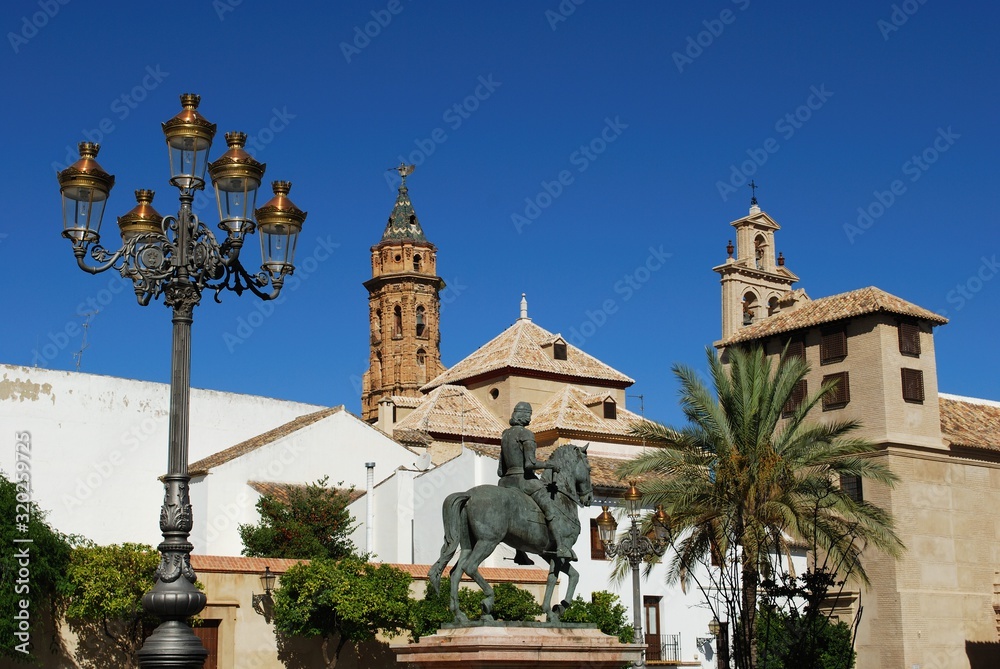 Plaza Guerrero Munoz with San Sebastian church and the Incarnation Convent in the centre and the statue of Fernando I (king of Aragon) in the foreground, Antequera, Spain.