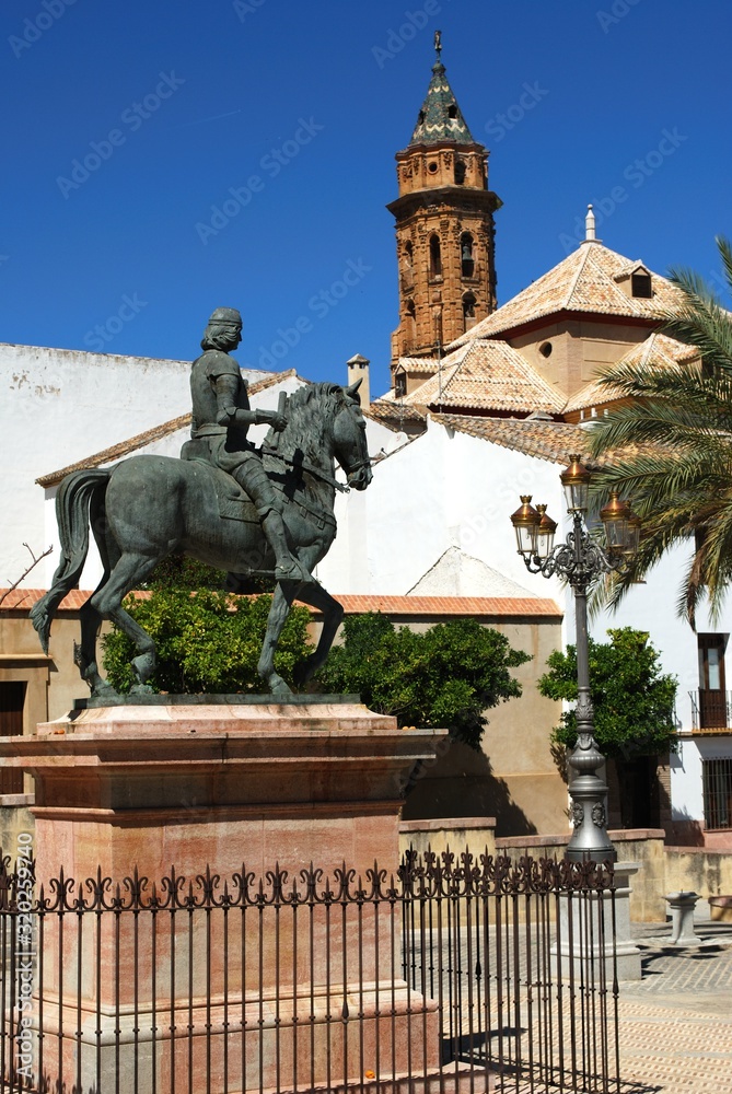 Obraz premium Plaza Guerrero Munoz with the San Sebastian church tower to the rear, the Incarnation Convent in the centre and the statue of Fernando I (king of Aragon) in the foreground, Antequera, Spain.