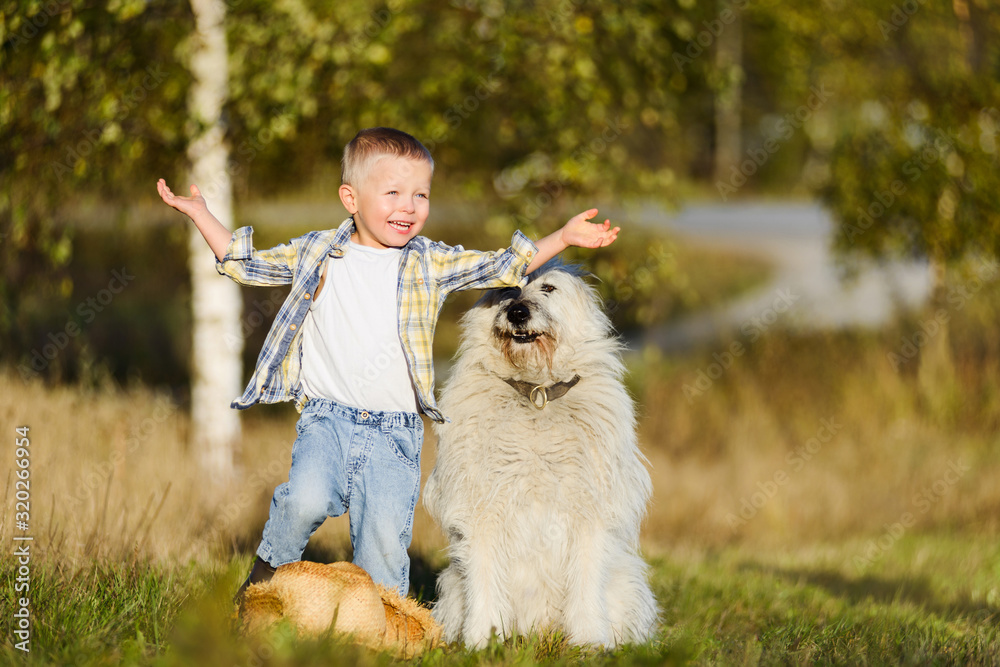 Happy smiling blond boy walking with dog friend on farm Happy smiling blond boy walking with dog friend on farm